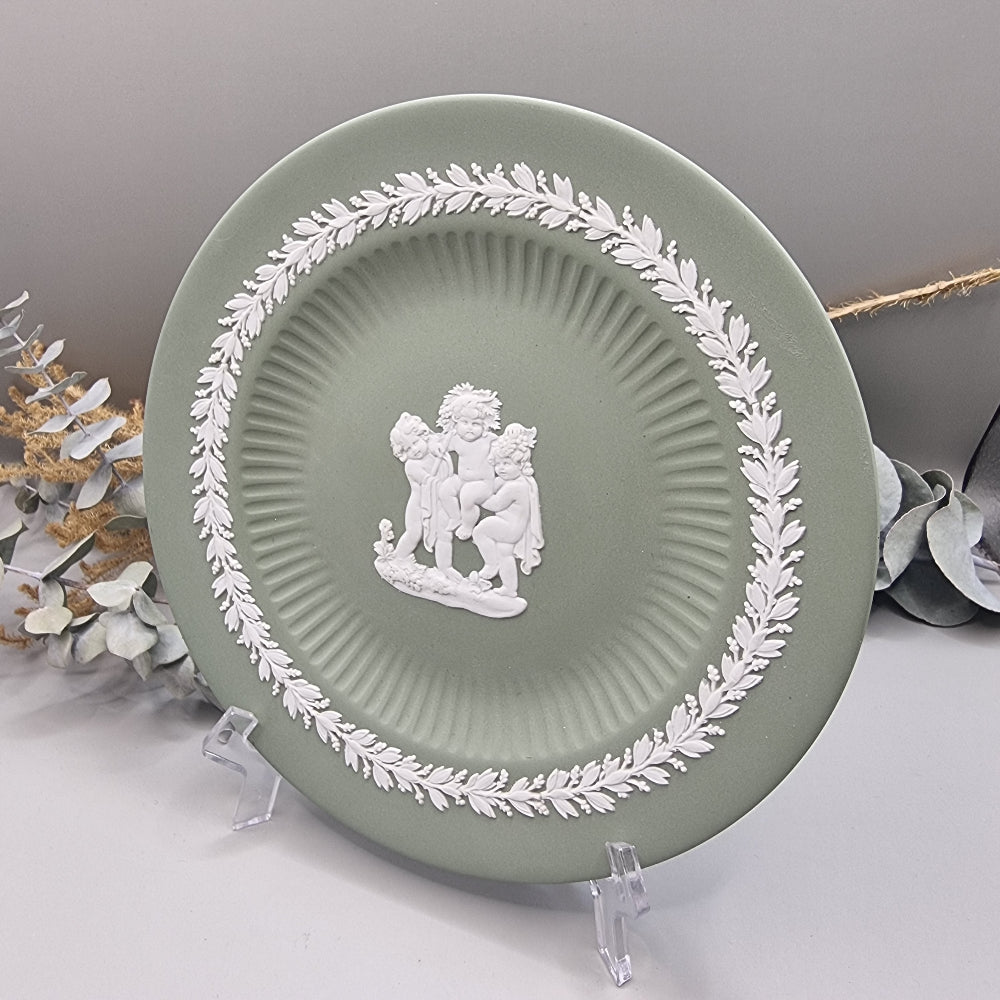 Sage green Jasperware plate with white cherub design and laurel border.