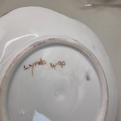 Scalloped porcelain dish with painted cranes and gold detailing.