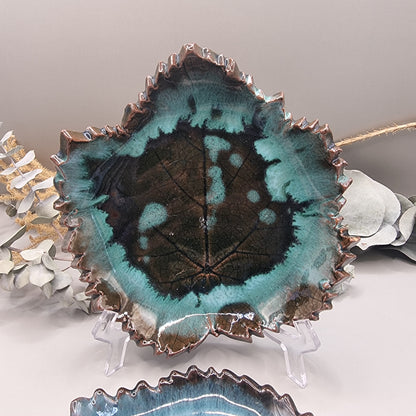 Set of 2 maple leaf-shaped ceramic dishes in teal and brown glaze with textured detail.