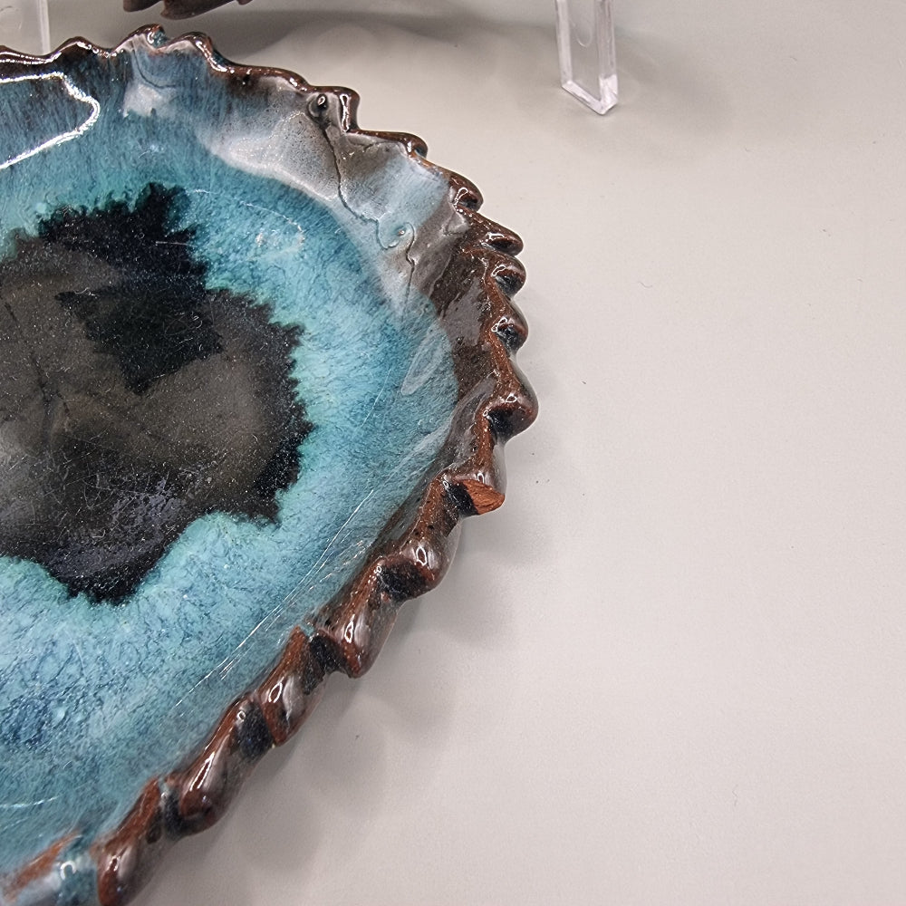 Set of 2 maple leaf-shaped ceramic dishes in teal and brown glaze with textured detail.