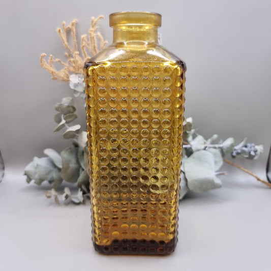 Amber textured glass bottle vase with honeycomb-style dots and squared shape, perfect for flowers or decor.