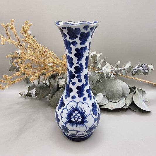 Blue and white bud vase with scalloped rim and floral pattern in dark blue.