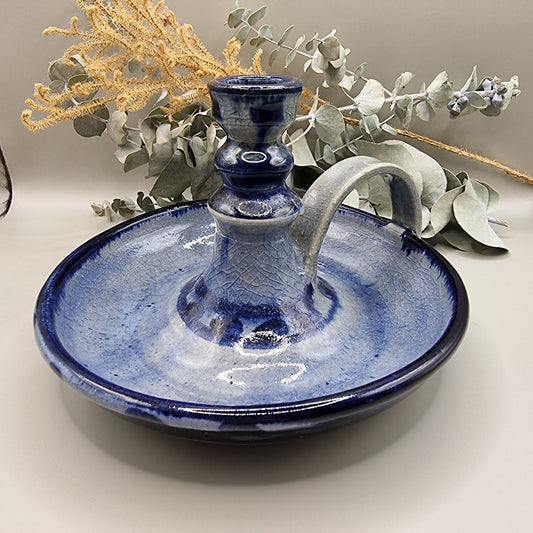 Blue glazed ceramic chamberstick with handle and crackle texture finish.