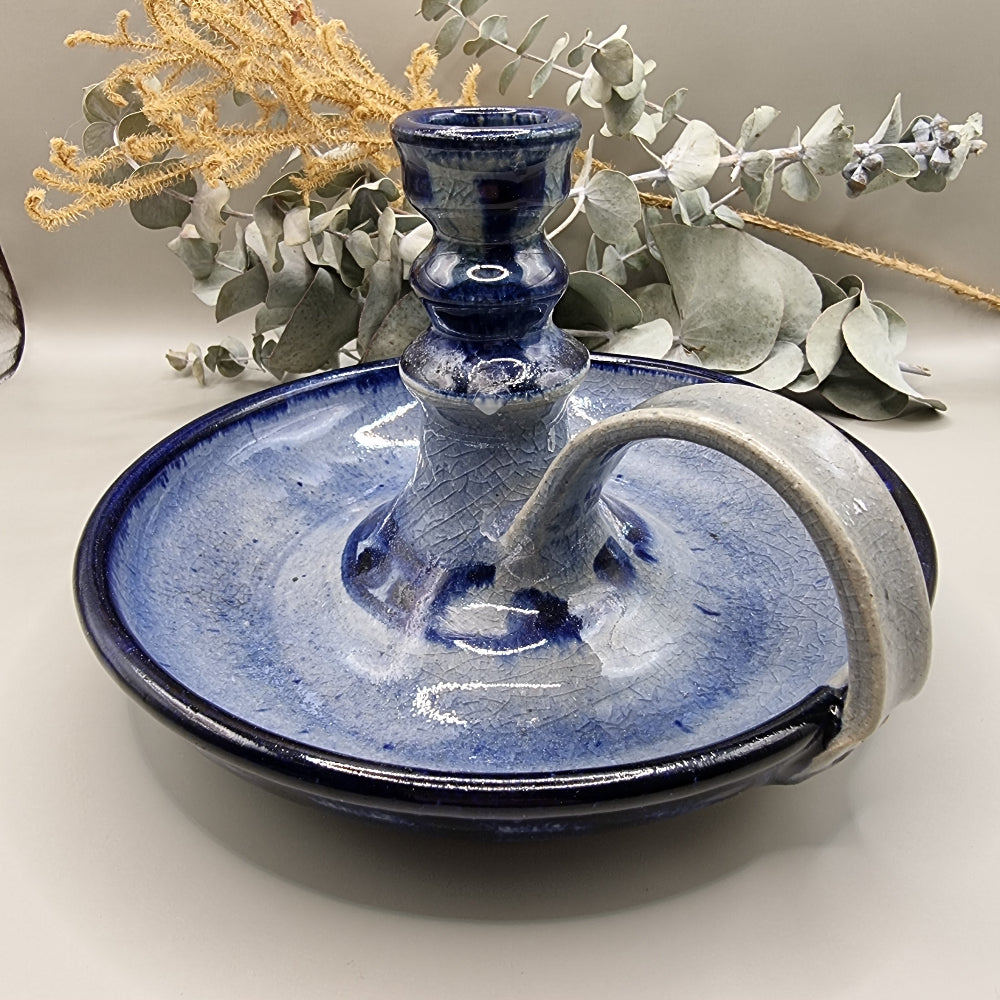 Blue glazed ceramic chamberstick with handle and crackle texture finish.