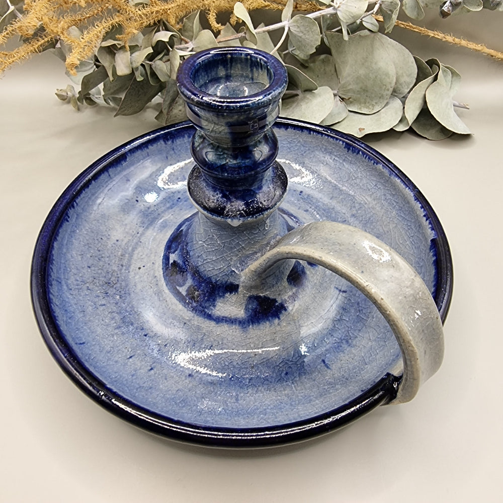 Blue glazed ceramic chamberstick with handle and crackle texture finish.