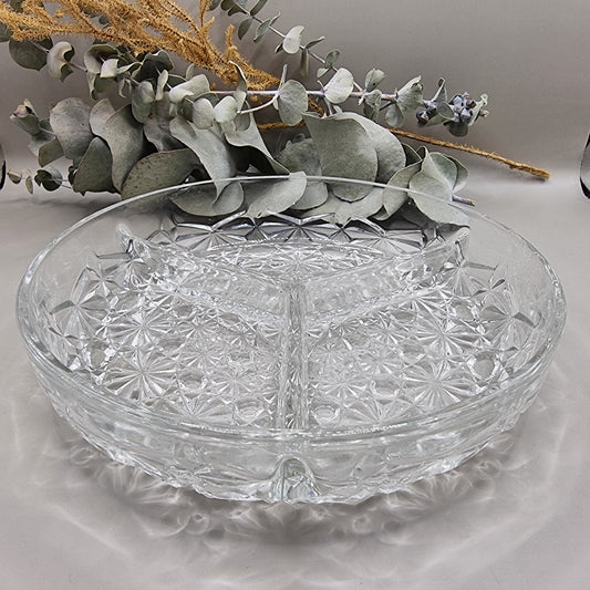Round clear glass serving dish with starburst pattern and three divided sections.