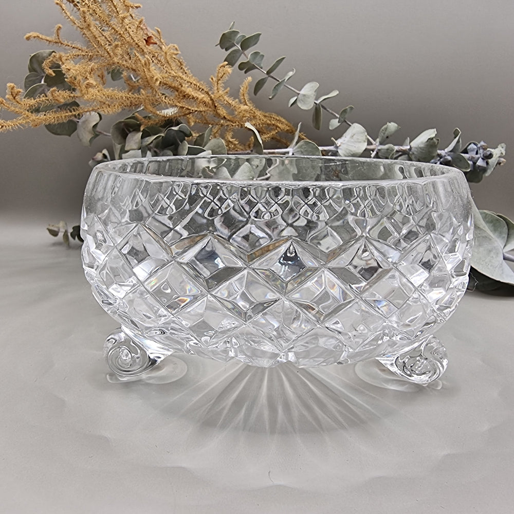 Small footed pressed glass bowl with diamond pattern and scroll feet.