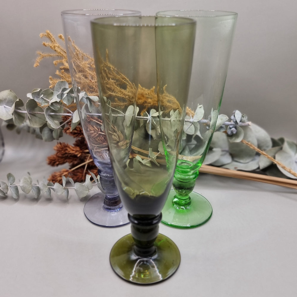 Set of 4 tall coloured glass flutes in green, grey, purple, and olive.

