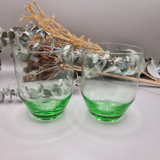 Pair of clear glass tumblers with vibrant green bases.