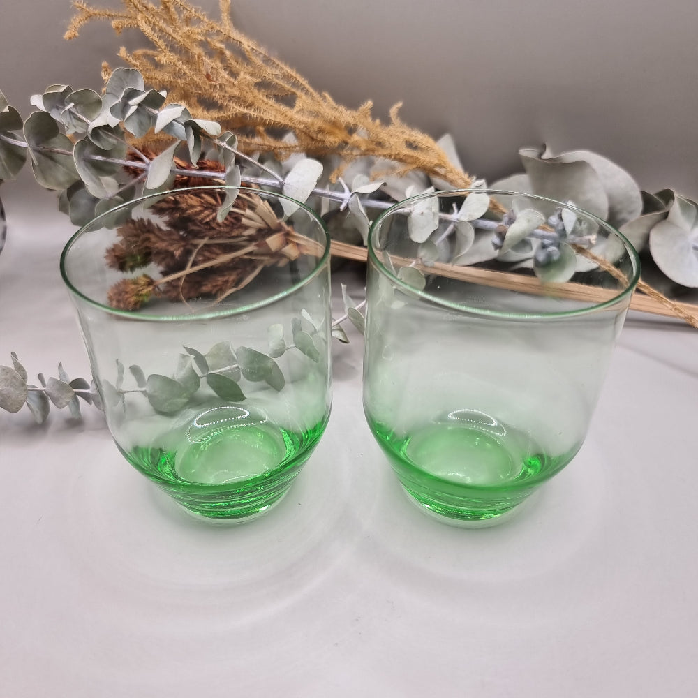 Pair of clear glass tumblers with vibrant green bases.