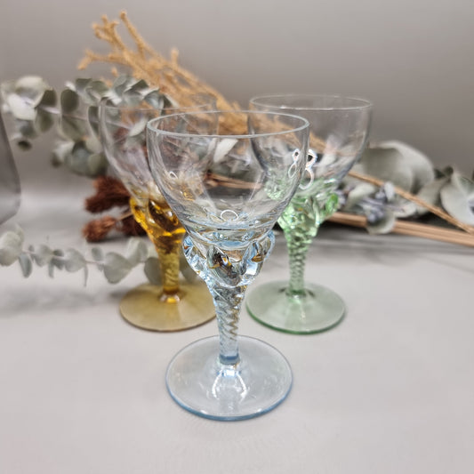 Set of 3 coloured liqueur glasses with twisted stems in blue, green, and amber.

