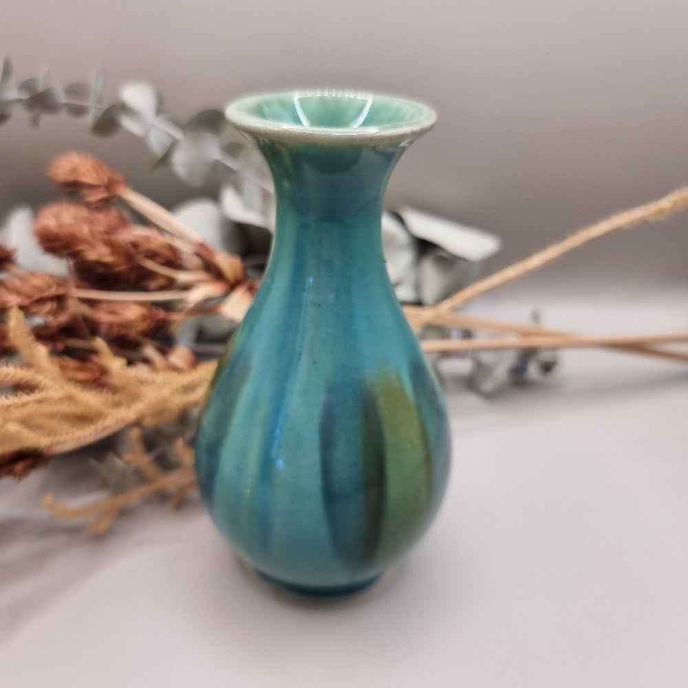 Small turquoise and green glazed studio pottery vase with rounded base and slender neck.