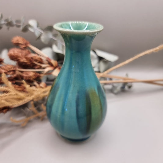 Small turquoise and green glazed studio pottery vase with rounded base and slender neck.