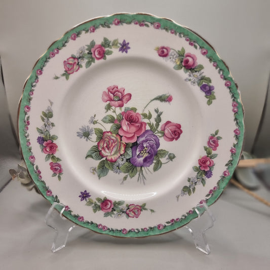 Royal Staffordshire “Nancy” plate by Clarice Cliff with green rim, floral border and central pink and purple rose bouquet.