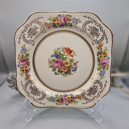 Johnson Bros Victorian square plate with floral centre and corner bouquets, gold edge and brown scroll detail.