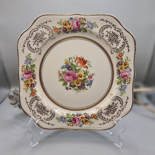 Johnson Bros Victorian square plate with floral centre and corner bouquets, gold edge and brown scroll detail.
