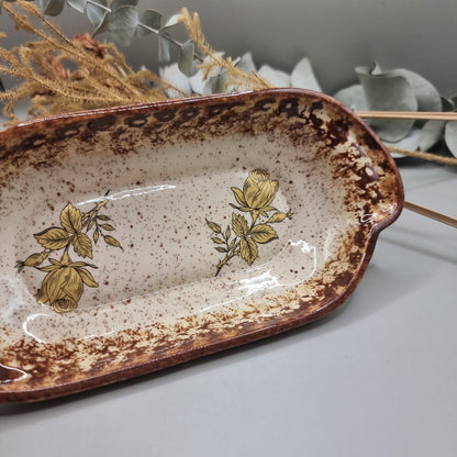 Rectangular speckled stoneware dish with brown glaze and yellow rose floral decals.
