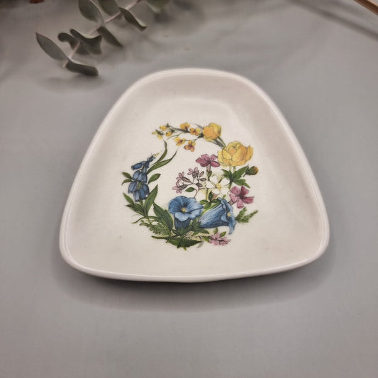 Triangular Guild Crafts Poole dish with colourful floral wreath and rounded edges.