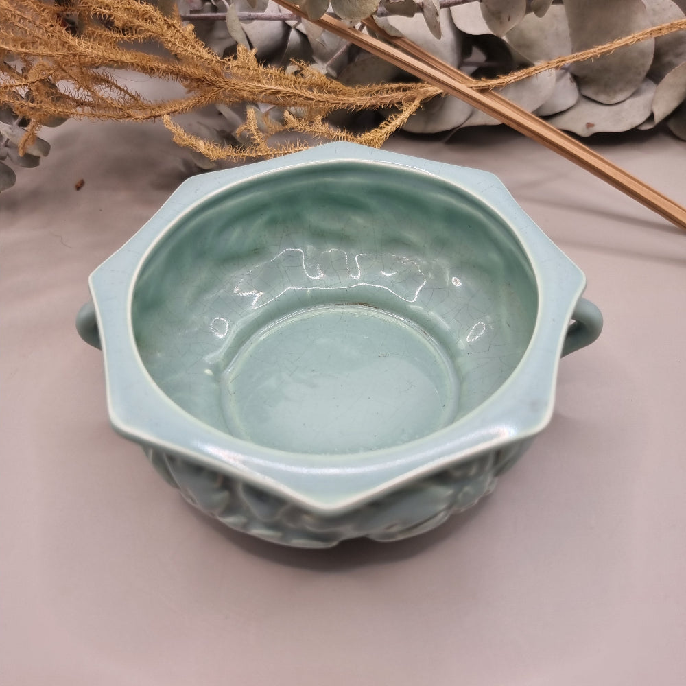 Pale teal ceramic bowl with embossed floral pattern and side handles