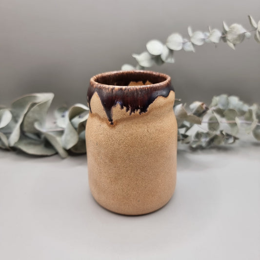 Studio pottery jar with sandy matte base and brown drip glaze rim