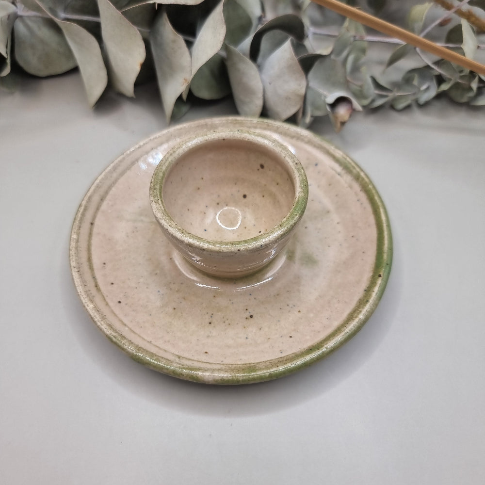 Handmade ceramic candle holder with cream glaze and green rim
