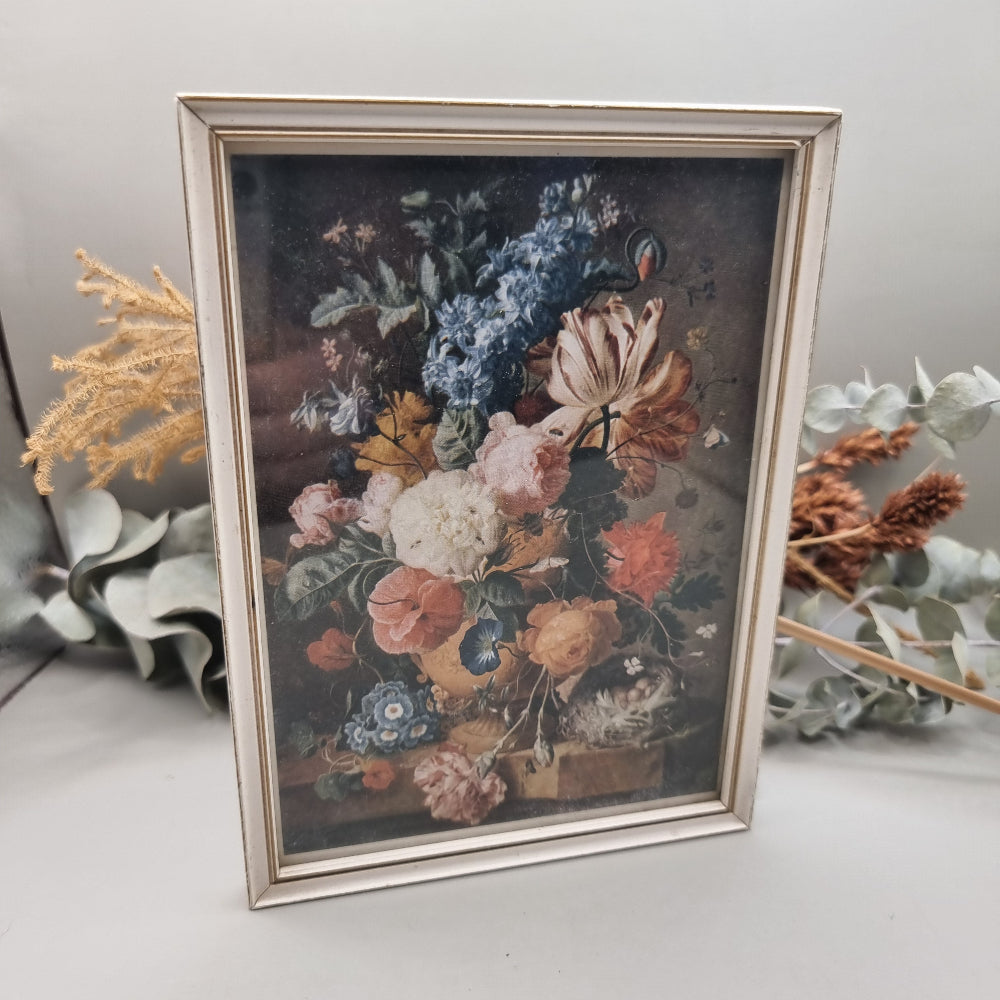 Vintage floral still life print in cream-toned frame with colourful bouquet.