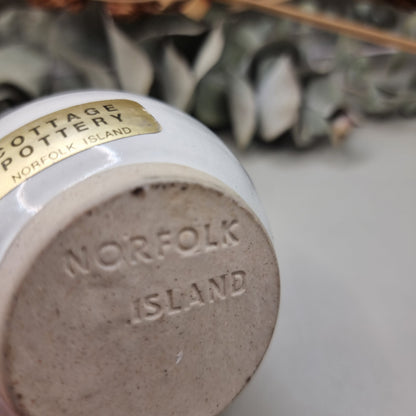 Norfolk Island pottery cup with pine tree design and blue rim