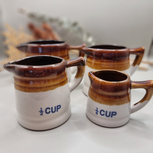 Vintage brown drip glaze stoneware measuring jugs set, marked ½ and ¼ cup.