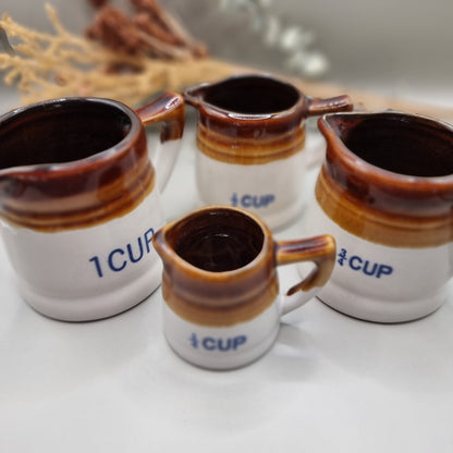 Vintage brown drip glaze stoneware measuring jugs set, marked ½ and ¼ cup.