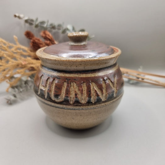 Vintage pottery honey pot with carved lettering reading “HUNNY”