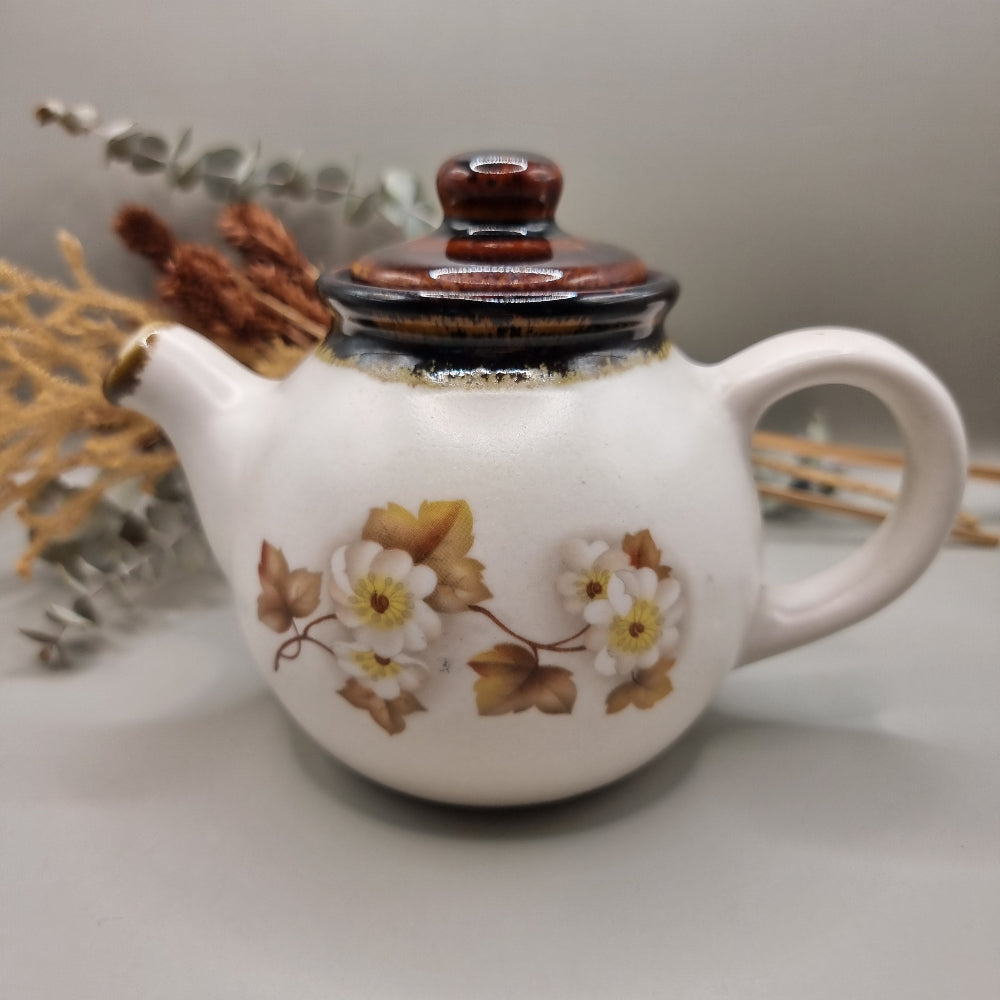 Stoneware teapot set with white floral design, includes teapot, creamer and sugar bowl.