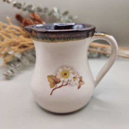 Stoneware teapot set with white floral design, includes teapot, creamer and sugar bowl.