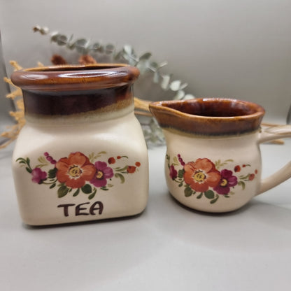 Floral ceramic tea jar and creamer jug with brown glaze and hand-painted flowers.