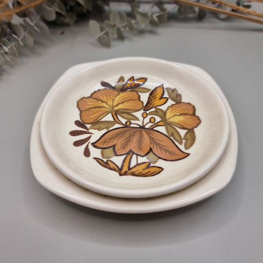 Two Palissy side plates with 70s floral pattern in orange, brown and yellow
