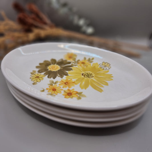 Set of four Crown Lynn Topaz plates with bold yellow and orange flowers.