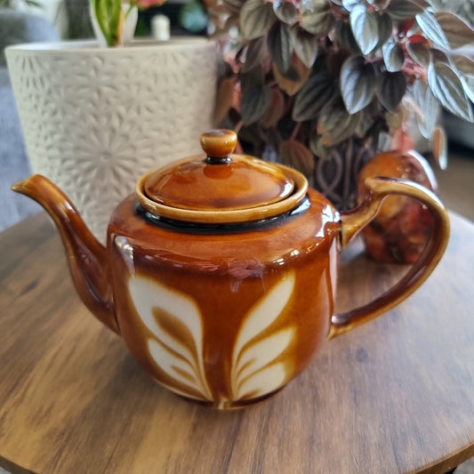 Vintage caramel and cream ceramic teapot with retro leaf design and matching lid