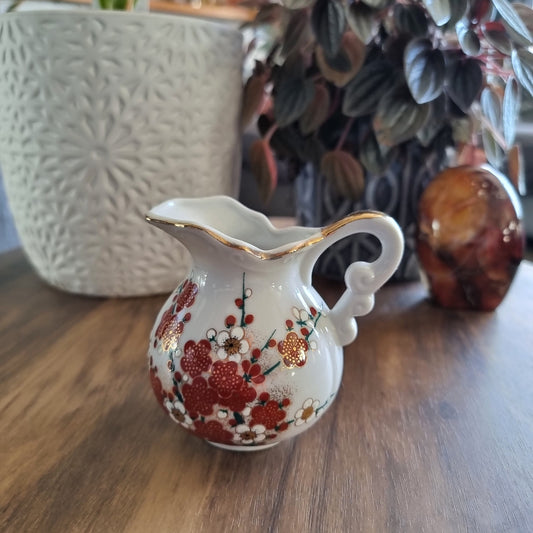 Vintage floral porcelain creamer jug with red and gold blossom design and gold trim