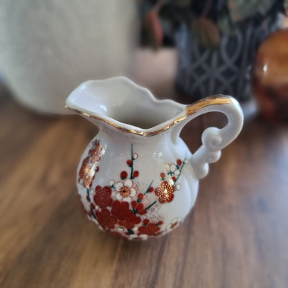 Vintage floral porcelain creamer jug with red and gold blossom design and gold trim