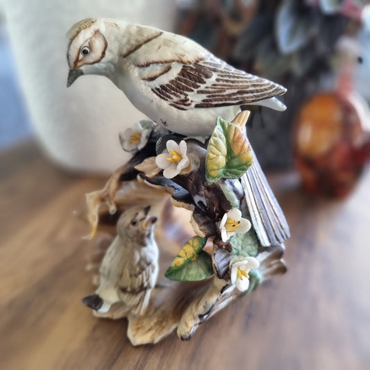 Vintage porcelain bird figurine with two birds, flowers, and leaves on a naturalistic base