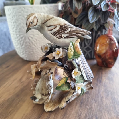 Vintage porcelain bird figurine with two birds, flowers, and leaves on a naturalistic base