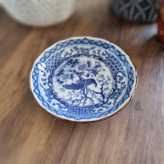 Vintage blue and white porcelain dish with bird and floral motif and scalloped edge
