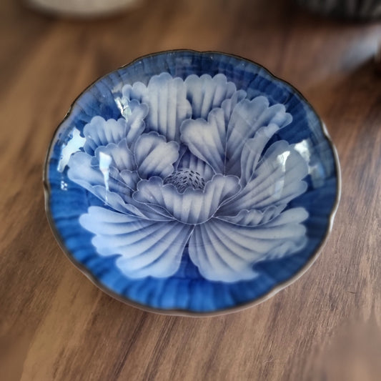 Blue porcelain dish with large blooming flower design and scalloped edge
