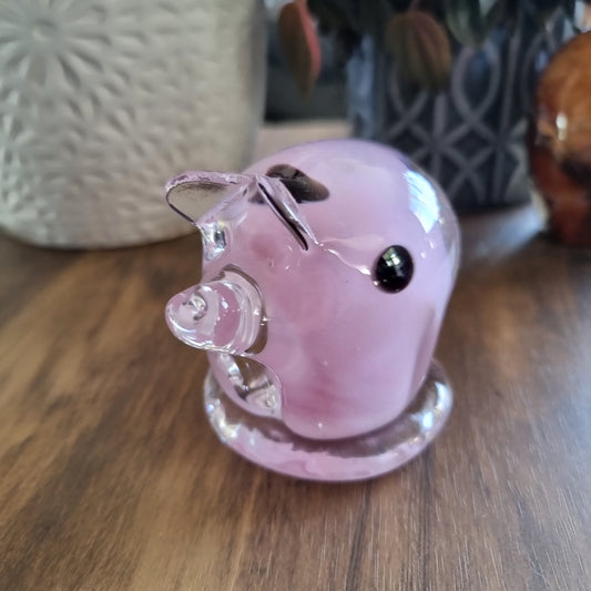 Pink and clear glass pig figurine with swirled design and clear base.