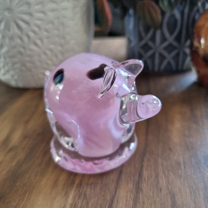 Pink and clear glass pig figurine with swirled design and clear base.