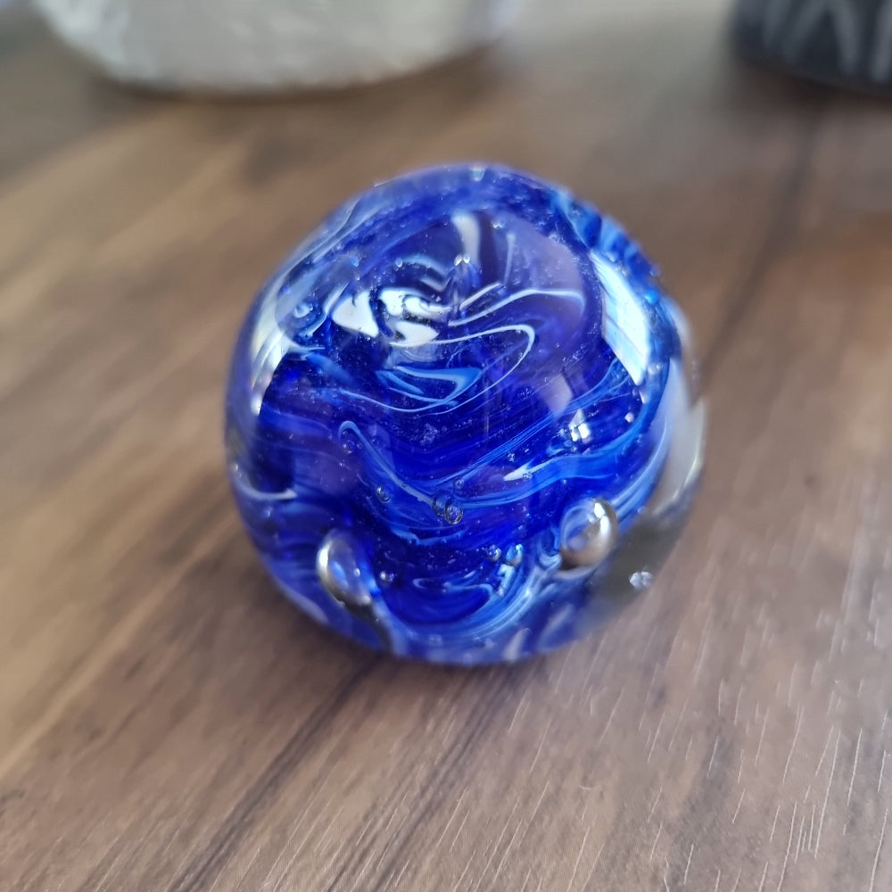 Cobalt blue swirl art glass paperweight with white and silver accents.