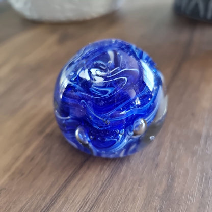 Cobalt blue swirl art glass paperweight with white and silver accents.