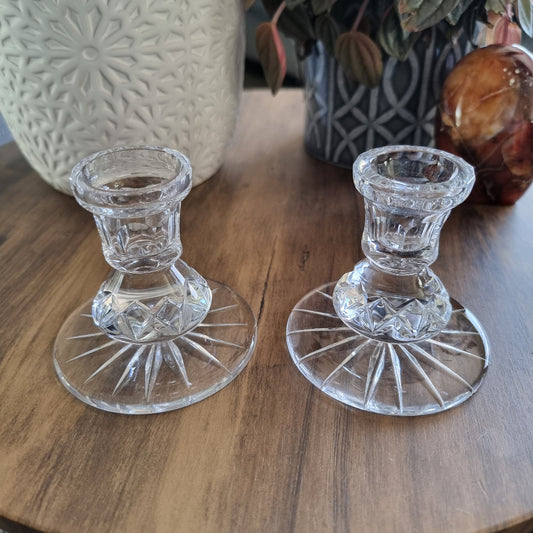 Pair of clear cut glass candle holders with starburst base design.