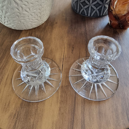 Pair of clear cut glass candle holders with starburst base design.