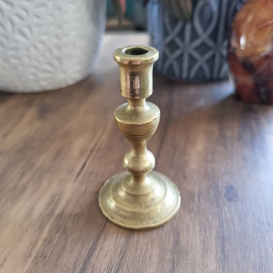 Small vintage brass candle holder with classic shape and tiered base.