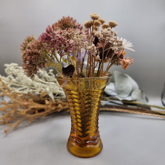 Amber ripple glass vase with hourglass shape and wavy texture.